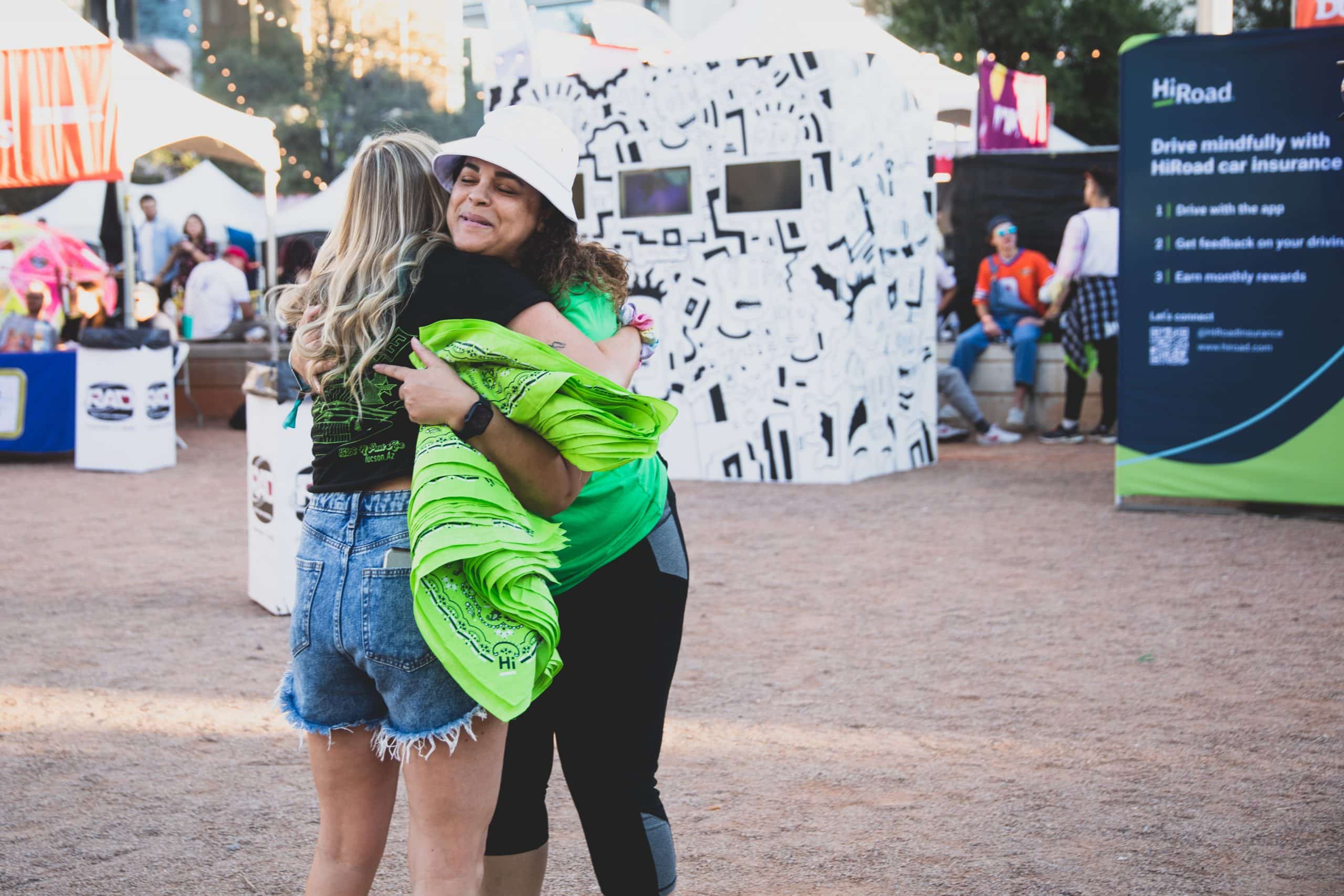 Evolve Activation Company brand ambassador giving a customer a hug at a festival.